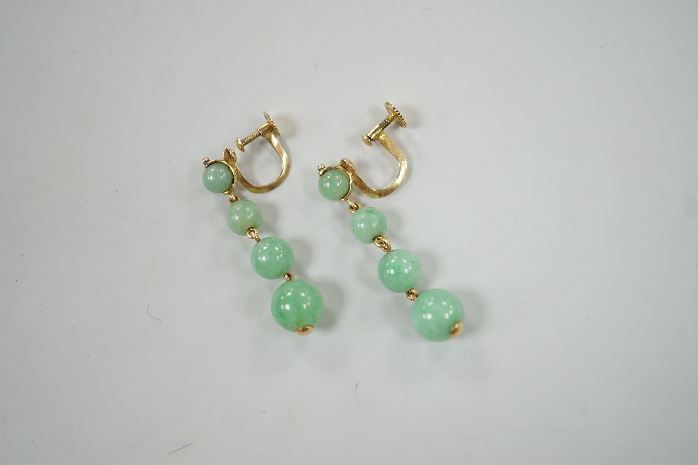 A pair of yellow metal and graduated four stone jade bead drop earrings, 39mm, gross weight 6.6 grams.